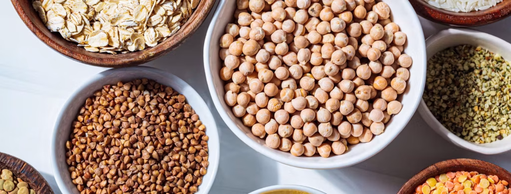 Ciotole di cereali e legumi: ceci, grano saraceno, fiocchi d'avena e lenticchie