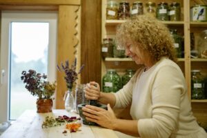 Come scegliere un naturopata: erborista al lavoro con le erbe